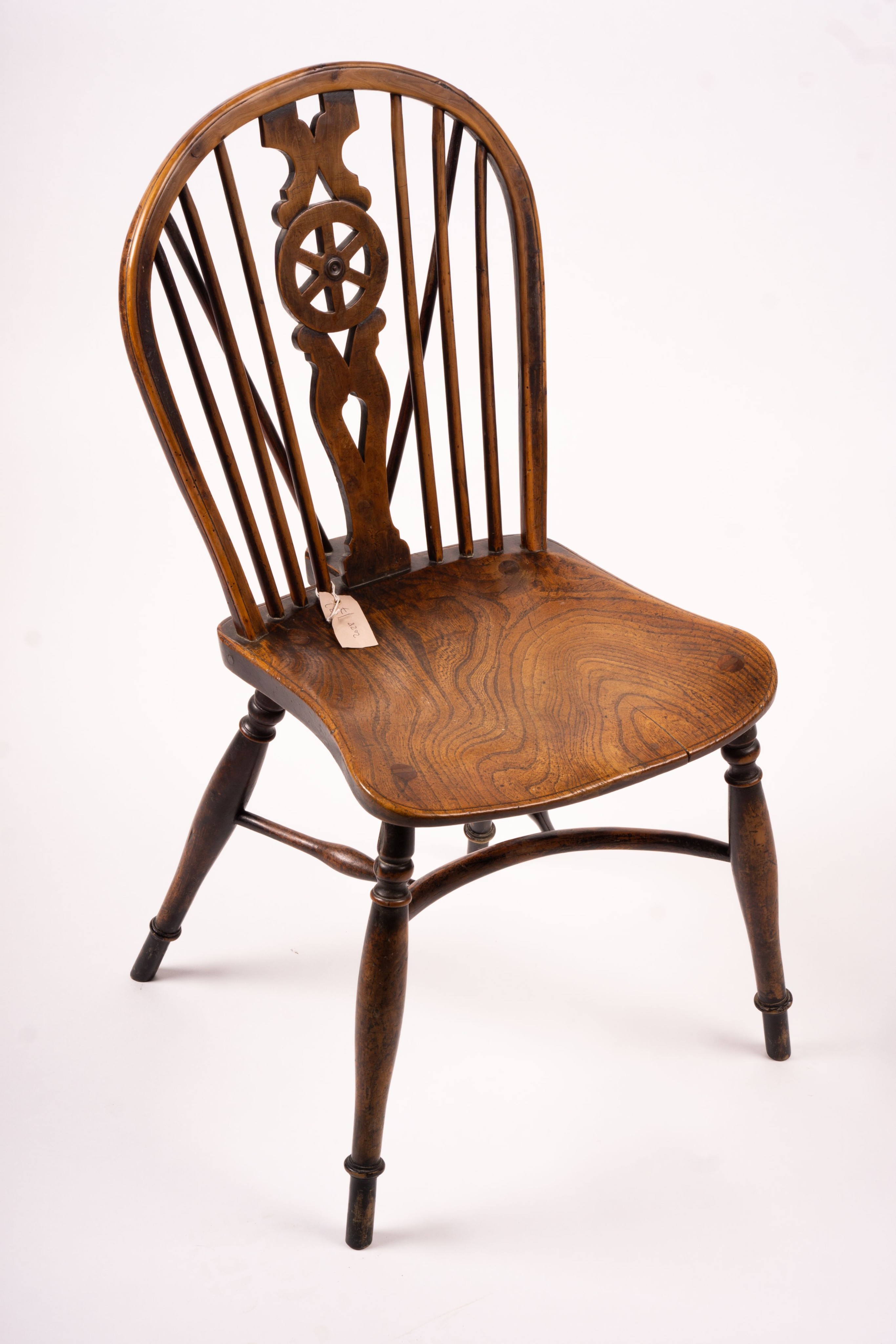 A mid 19th century ash and elm Derbyshire area Windsor elbow chair, together with a 19th century yew and elm Windsor wheel back chair with crinoline stretcher